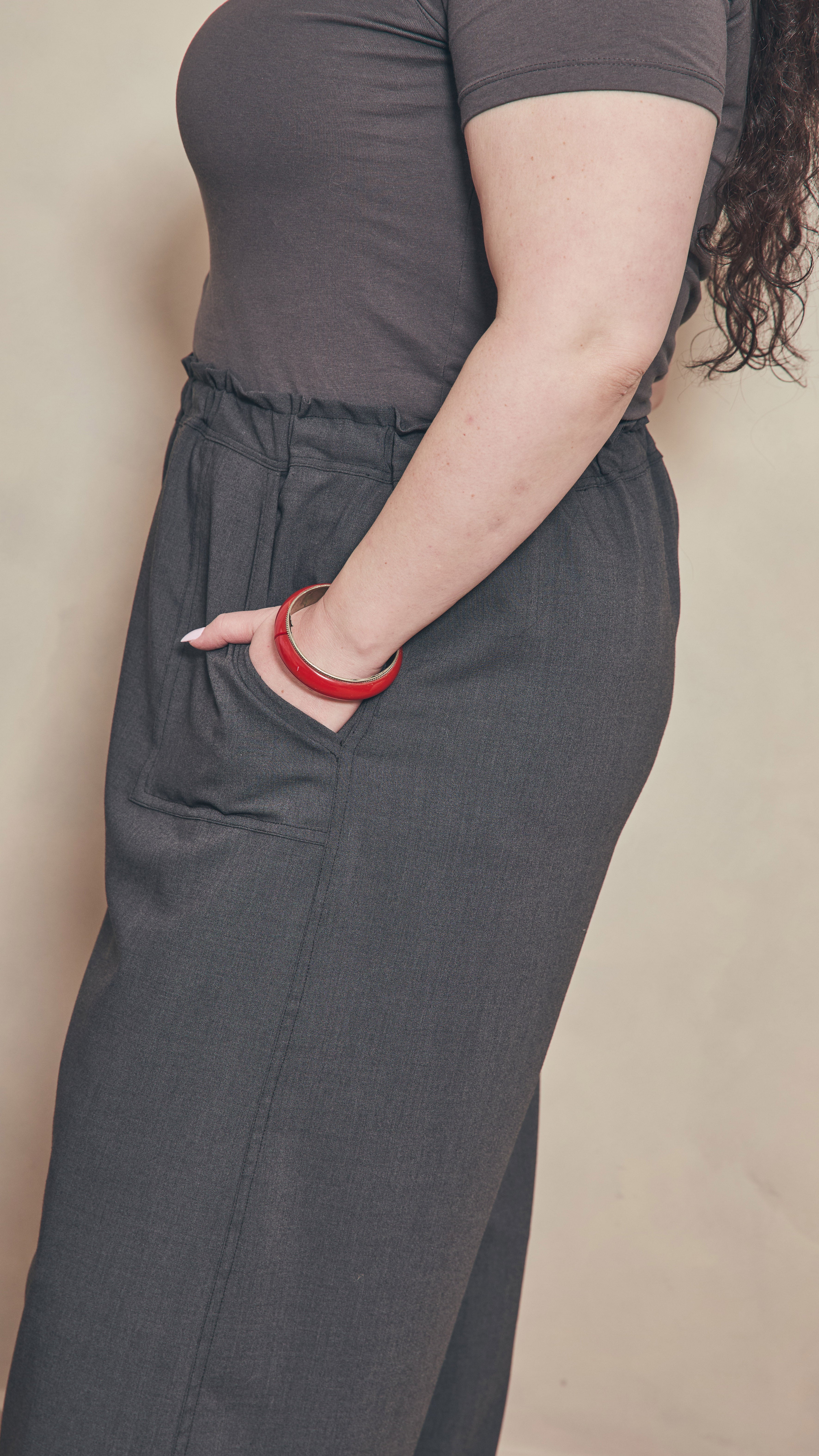 Side view of charcoal pants showing contrast double stitching on the side seam.