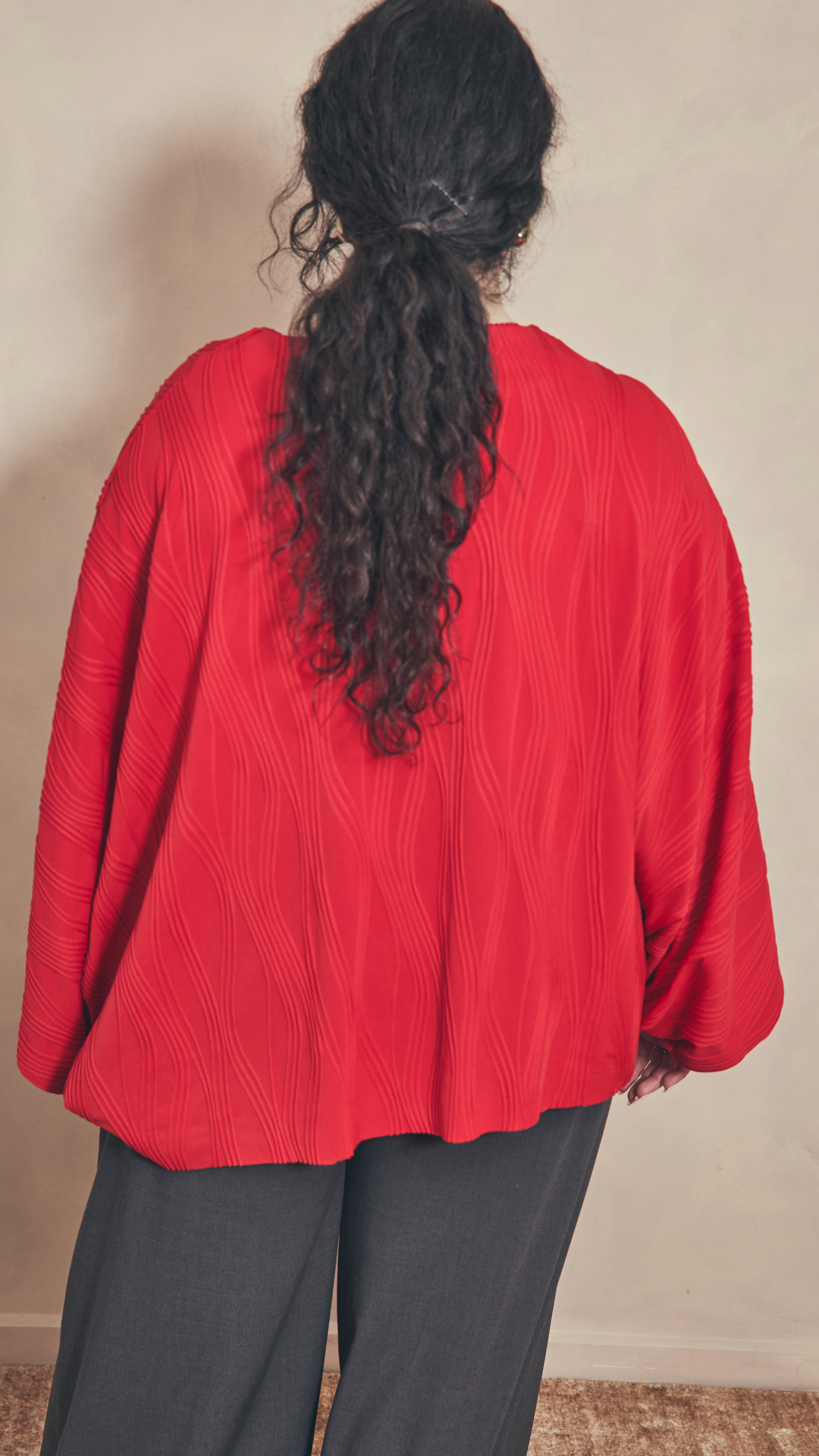 Back view of dolman top. Modal has long black curly hair in ponytail